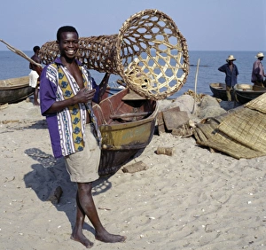 A young man carries a wicker fish trap A young man carries a wicker fish trap