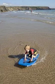 Boy playing in sea with boogie board