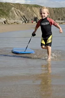 Boy playing in sea with boogie board (rr)
