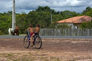 Kids cycling around highway, Sangue, Maranhao, Brazil Kids cycling around highway, Sangue, Maranhao, Brazil