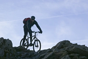 A mountain biker descending Helvellyn in the Lake District UK A mountain biker descending Helvellyn in the Lake District UK