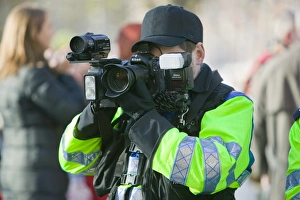 Police photographer photographing protestors at a climate change rally in London December Police photographer photographing protestors at a climate change rally in London December