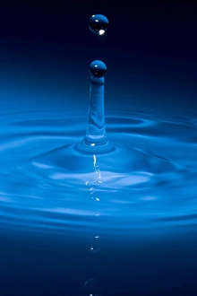 Splash-back column caused by a single water drop falling into water. A droplet has just broken off from water column Splash-back column caused by a single water drop falling into water. A droplet has just broken off from water column
