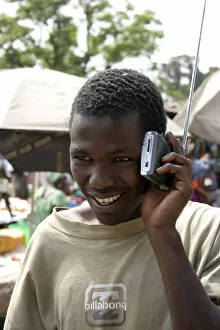 Banjul Collection: Albert Market Russell Street. Young African man smiling while listening to a radio which he is