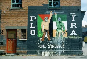 Prints of Ireland, North, Belfast, PLO IRA Irish Republican mural on the side of a terrace house on the corner with Falls Road Related Prints: Belfast Mural Print