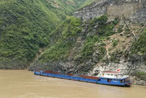 China, Hubei, Three Gorges Barge loading coal from a gravity chute in the Wu Gorge China, Hubei, Three Gorges Barge loading coal from a gravity chute in the Wu Gorge