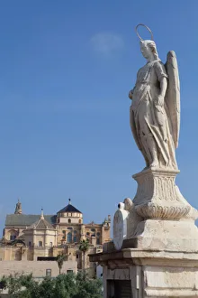 Spain, Andalucia, Cordoba, Statue of San Rafael patron saint of Cordoba on the Roman Bridge with the Mezquita Cathedral in the background EyeUbiquitous_201114528