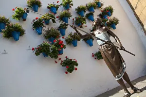 Spain, Andalucia, Cordoba, Statue of a woman watering potted plants with a cane, symbolizing the present of the Cordoba Patios party, by artist Jose Manuel Belmonte EyeUbiquitous_201114543