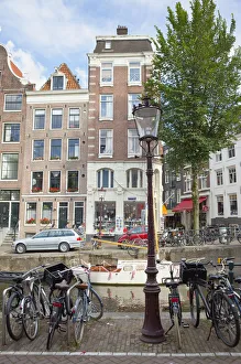 Holland, North, Amsterdam, Bicycles parked next to canal Holland, North, Amsterdam, Bicycles parked next to canal