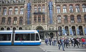 Holland, North, Amsterdam, Exterior of Magna Plaza store with tram and pedestrian crossing