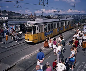 HUNGARY, Budapest Electric yellow tram and groups of people gathered at tram stop HUNGARY, Budapest Electric yellow tram and groups of people gathered at tram stop