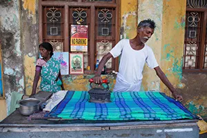 India, Pondicherry, Man ironing linen in Pondicherry India, Pondicherry, Man ironing linen in Pondicherry