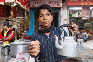 India, Uttar Pradesh, Varanasi, A chai boy serving tea
