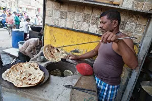 India, Uttar Pradesh, Varanasi, A cook making tandoori roti at a food hotel