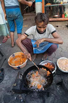 India, West Bengal, Kolkata, A man cooks chicken pakora on the street