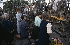 LITHUANIA, Hill of Crosses Men and women pray in front of hundreds of crosses LITHUANIA, Hill of Crosses Men and women pray in front of hundreds of crosses