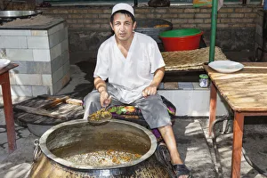 Man cooking plov, typical traditional Uzbek food, Navoi Province, Uzbekistan Man cooking plov, typical traditional Uzbek food, Navoi Province, Uzbekistan