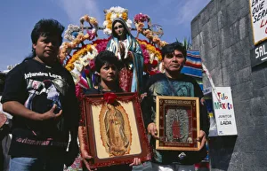 MEXICO, Mexico City Pilgrims carrying icons and standing in front of statue of the MEXICO, Mexico City Pilgrims carrying icons and standing in front of statue of the