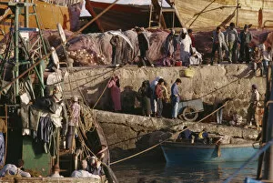 Images Dated 24th July 2008: MOROCCO Essaouira Busy port scene with moored fishing boat and crowds on stone quay