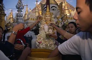 MYANMAR, Yangon People making offerings of flowers and water at shrine in Shwedagon MYANMAR, Yangon People making offerings of flowers and water at shrine in Shwedagon