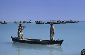 QATAR, Khor Fishermen in a wooden canoe with fishing boats at anchor beyond QATAR, Khor Fishermen in a wooden canoe with fishing boats at anchor beyond