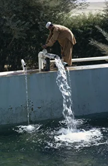 QATAR Man letting water into irrigation pool on a farm QATAR Man letting water into irrigation pool on a farm