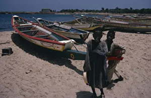 Related Images Gallery: SENEGAL Two children on beach beside line of painted fishing boats pulled up onto the