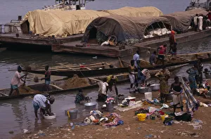 Related Images Gallery: SENEGAL, Niger River Women washing clothes in river from bank with barges