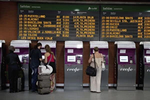 Spain, Madrid, Passengers using the self-service ticket machines in front of the