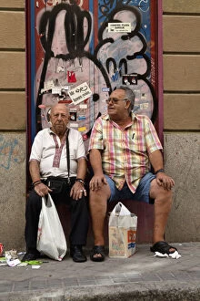 Images Dated 22nd August 2014: Spain, Madrid, Two visitors to the El Rastro Flea market take a rest from shopping