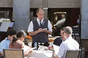 Spain, Madrid, Waiter taking orders from diners at a restaurant in the Plaza Mayor Spain, Madrid, Waiter taking orders from diners at a restaurant in the Plaza Mayor