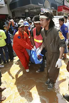 Tsunami carnage the day after. Bodies of foreign tourists are brought out of a flooded supermarket which was in