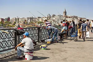 Turkey, Istanbul, Men fishing on Galata Bridge, Galata Tower in background Turkey, Istanbul, Men fishing on Galata Bridge, Galata Tower in background
