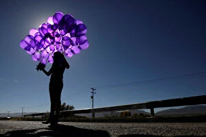 Juarez Gallery: Activist holds purple balloons at El Navajo creek during a ceremony to mark the