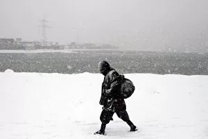 Images Dated 14th January 2012: An Afghan man walks during a snowy day in Kabul