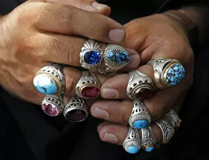 Images Dated 9th September 2010: Afghan vendor wears rings on his fingers to attract customers ahead of Eid-al-Fitr in