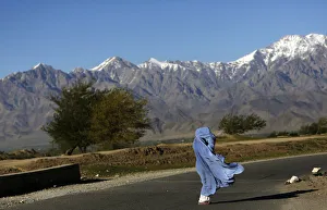 An Afghan woman in a burqa walks along a road on a windy day on the outskirts of Kabul An Afghan woman in a burqa walks along a road on a windy day on the outskirts of Kabul