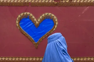 An Afghan woman walks past a decoration on the side of a traditional Reksha motor-taxi An Afghan woman walks past a decoration on the side of a traditional Reksha motor-taxi