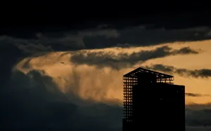 An aircraft flies past a building under construction on a stormy evening in Moscow An aircraft flies past a building under construction on a stormy evening in Moscow