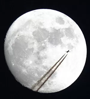 Images Dated 26th April 2010: An aircraft passes in front of the moon above Manchester