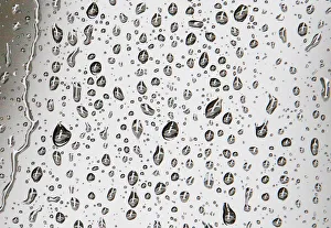 An airplane waiting to depart the gate is reflected in rain drops on a window at Logan An airplane waiting to depart the gate is reflected in rain drops on a window at Logan