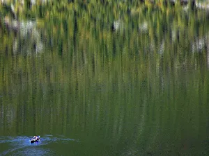 Two Albanians fish from their boat on a lake in the northeast of Kukes city Two Albanians fish from their boat on a lake in the northeast of Kukes city
