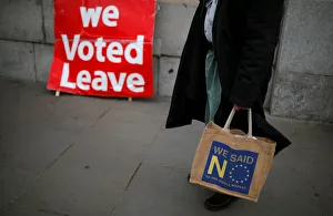 Anti-Brexit supporter stands in front of a pro-Brexit sign in London Anti-Brexit supporter stands in front of a pro-Brexit sign in London