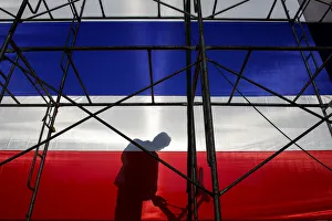 An anti-government protester casts a shadow behind a large Thai national flag during a An anti-government protester casts a shadow behind a large Thai national flag during a