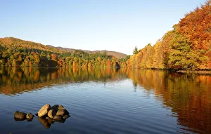 Autumn trees are reflected in the water of Faskally Loch near Pitlochry, Scotland Autumn trees are reflected in the water of Faskally Loch near Pitlochry, Scotland