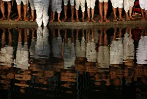 Bare feet of devotees are pictured as they stand on the bank of the Hanumante River while Bare feet of devotees are pictured as they stand on the bank of the Hanumante River while