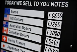 A board displaying buying and selling rates is seen outside of a currency exchange outlet A board displaying buying and selling rates is seen outside of a currency exchange outlet