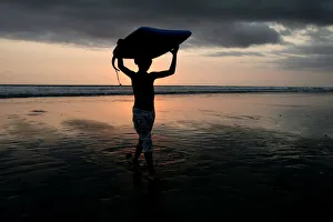 A boy carries his boogie board near Kuta beach on the Indonesian resort island of Bali A boy carries his boogie board near Kuta beach on the Indonesian resort island of Bali