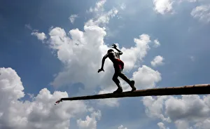 A boy climbs up a greasy pole in a climbing competition at a part of Sinhala A boy climbs up a greasy pole in a climbing competition at a part of Sinhala