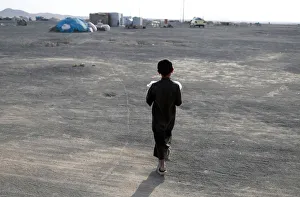 A boy, displaced from fighting in the Islamic State stronghold of Raqqa walks in desert A boy, displaced from fighting in the Islamic State stronghold of Raqqa walks in desert
